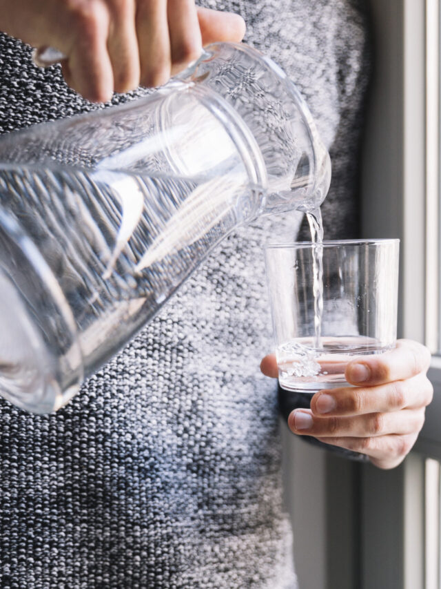 crop-man-pouring-water-near-window